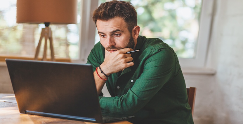 Een zzp'er zit achter laptop en is bezig met zijn verzekeringen