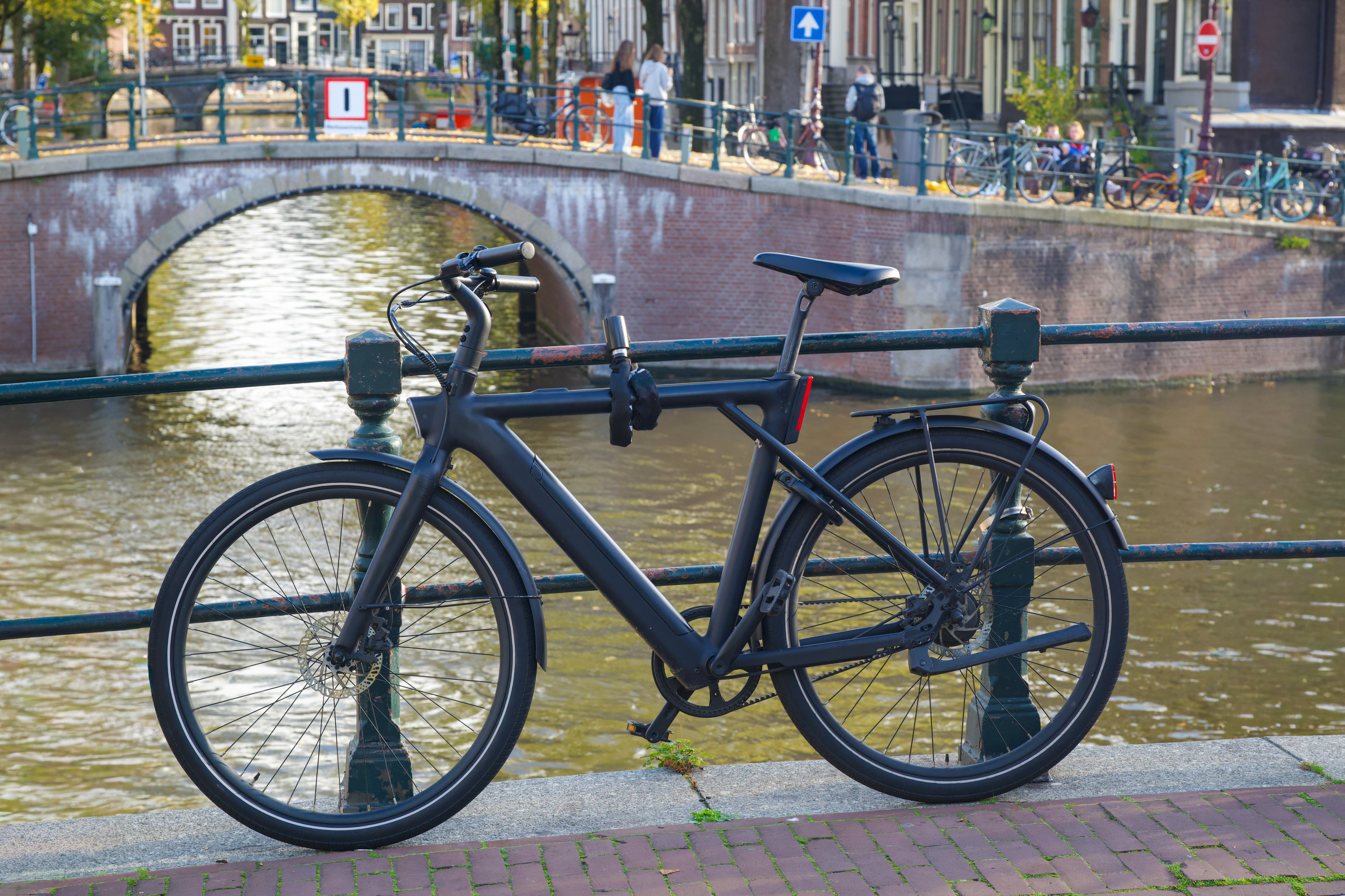 Een elektrische fiets aan een gracht in Amsterdam. Voorkom dat je elektrische fiets gestolen wordt met deze handige tips. 